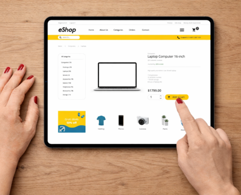 Hand mit rotem Nagellack wählt einen 16-Zoll-Laptop auf einem Tablet im eShop aus.